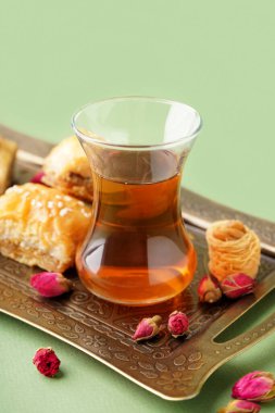 Bir bardak çay, Türk lezzeti ve arka planda kurumuş güller.