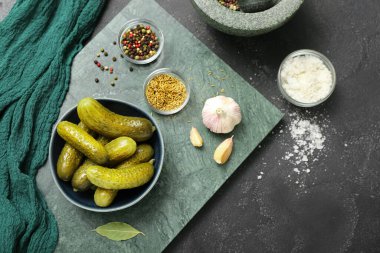 Lezzetli mayalanmış salatalıklı kase koyu grunge arka planda