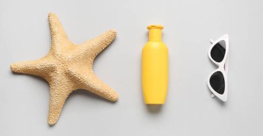 Deniz yıldızı, güneş kremi ve arka planda güneş gözlüğü. 