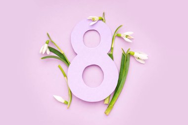 Beautiful snowdrops and number 8 on lilac background