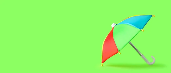 テキストのためのスペースと緑の背景にミニカラフルな傘 — ストック写真