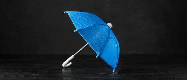黑色背景上有水滴的迷你蓝色伞 — 图库照片
