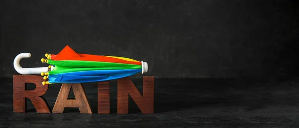 Mini Regenschirm Und Wort Rain Auf Schwarzem Hintergrund Mit Platz — Stockfoto