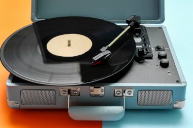 Renk arkaplanında vinil diski olan kayıt oynatıcı, kapat