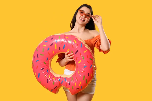 Turuncu Arka Planda Donut Şeklinde Şişirilebilir Halkası Olan Genç Bir — Stok fotoğraf