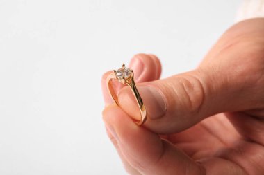 Beyaz arka planda altın nişan yüzüğü olan adam, yakın plan.