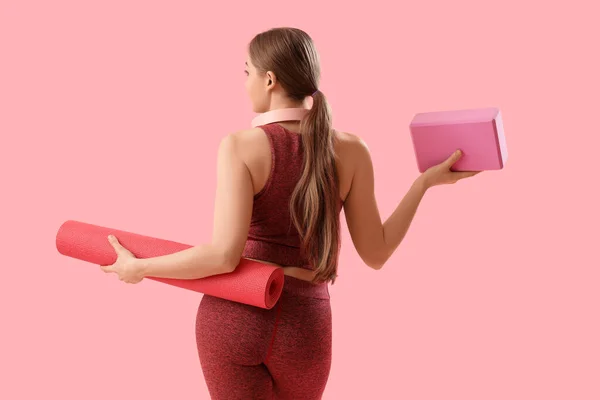 一个身材苗条的年轻女子 带着垫子和粉色背景的瑜伽块 — 图库照片