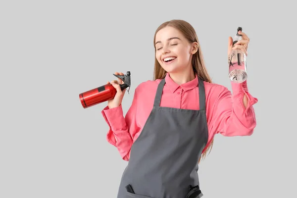 Vrouwelijke Kapper Met Sprays Grijze Achtergrond — Stockfoto