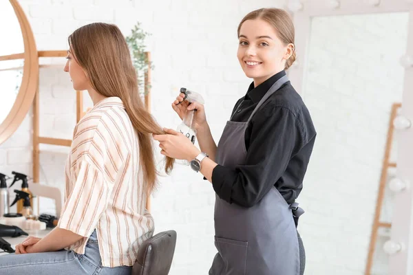 Kobieta Fryzjer Spryskując Włosy Młodej Kobiety Salonie Piękności — Zdjęcie stockowe
