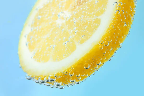Citronskiva Vatten Med Bubblor Blå Bakgrund — Stockfoto