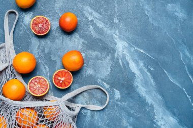 Mavi grunge arka planında lezzetli kan portakalları olan ağ torbası.