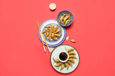 Lezzetli Çin jiaozi tabakları ve kırmızı arka planda sos.