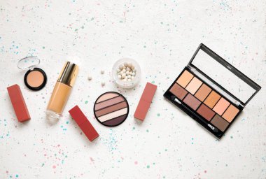 Grunge arka planında ruj lekeleri olan dekoratif kozmetik ürünler.