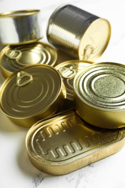 Beyaz mermer masa üzerinde balık olan farklı teneke kutular.