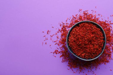 Mor arka planda safran yığını olan bir kase