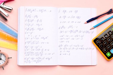 Matematik formülleri, hesap makineleri ve pembe arkaplan üzerindeki kırtasiye kitapçığı