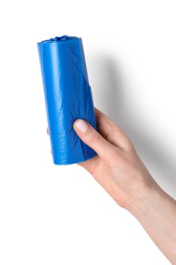 Beyaz arka planda çöp torbası rulosu tutan kadın.