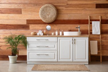 Lavabosu, çekmecesi ve merdiveni olan bir banyo.