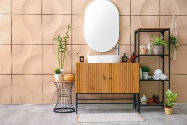 Lavabosu, çekmecesi ve raf ünitesi olan şık bir banyo.