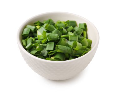 Beyaz arka planda taze kesilmiş yeşil soğanlı kase