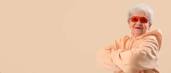 Elegante Donna Anziana Occhiali Sole Felpa Con Cappuccio Sfondo Beige — Foto Stock