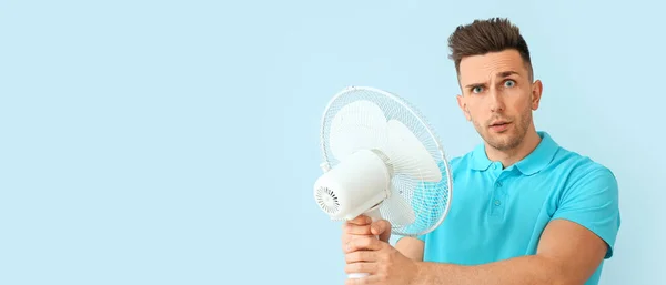 Hombre Confundido Con Ventilador Eléctrico Sobre Fondo Azul Claro Con —  Fotos de Stock