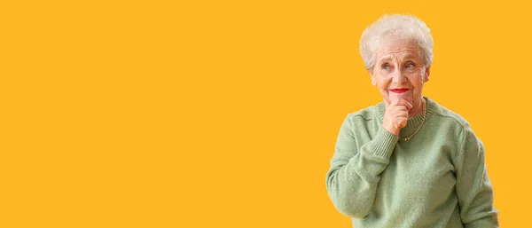 思考年上の女性で緑のセーター上の黄色の背景とともにスペースのためにテキスト — ストック写真