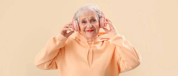 Senior Woman Headphones Listen Music Beige Background — Stock Photo, Image
