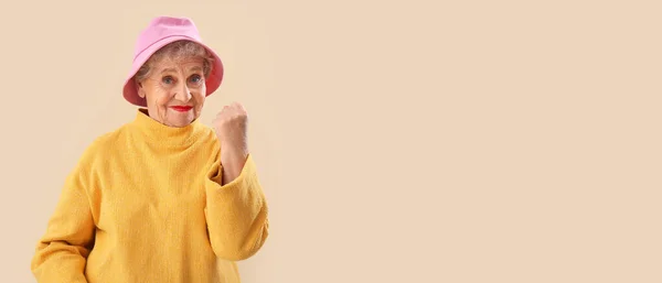 Senior Woman Bucket Hat Showing Clenched Fist Beige Background Space — Stock Photo, Image