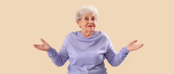 Confused Senior Woman Lilac Sweater Beige Background — ストック写真