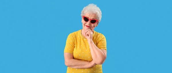 Senior Vrouw Gele Jurk Stijlvolle Zonnebril Lichtblauwe Achtergrond — Stockfoto