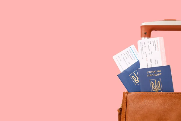装有乌克兰护照 火车票和粉色背景手提箱的袋子 — 图库照片