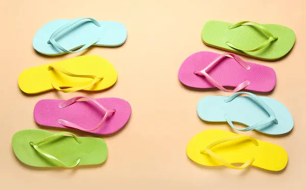 stock image Frame made of colorful flip-flops on beige background