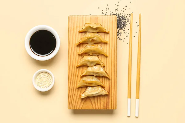 Houten Plank Met Lekkere Chinese Jiaozi Sesam Saus Beige Ondergrond — Stockfoto