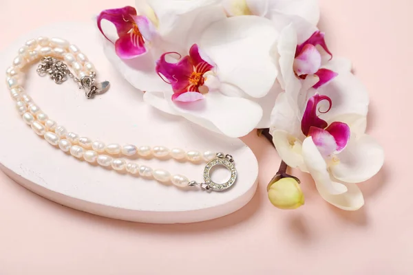 Stojak Ekspozycyjny Perłowym Naszyjnikiem Kwiatami Storczyków Różowym Tle Zbliżenie — Zdjęcie stockowe