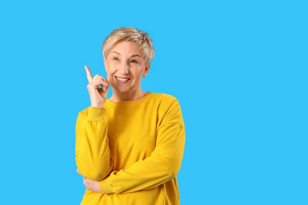 Dreaming Mature Woman Pointing Something Blue Background — Stock Photo, Image