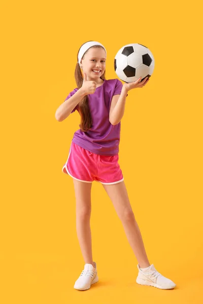 Sportowa Dziewczynka Piłką Nożną Pokazuje Kciuk Góry Żółtym Tle — Zdjęcie stockowe