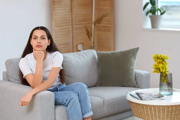 自宅でソファの上の思慮深い若い女性 — ストック写真
