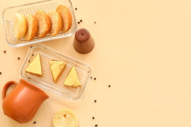 Sarı arka planda lezzetli işlenmiş peynir ve kızarmış ekmek üçgenleriyle dolu bir tabak.