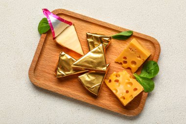 Lezzetli işlenmiş üçgen ve açık arkaplanda İsviçre peyniri olan ahşap tahta tahta.