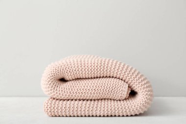 Işık duvarının yanındaki masada yeni örülmüş bir battaniye.