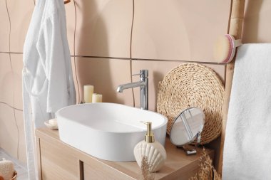 Banyo aksesuarlı lavabo lavabosu banyodaki masada.