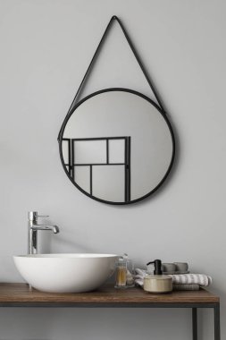 Lavabolu masa, banyo aksesuarları ve banyoda ayna.