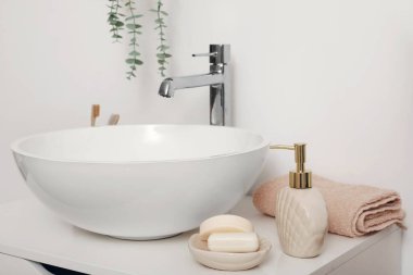Lavabo, sabun makinesi ve banyodaki çekmecelerin üzerine barlar, yakın plan.