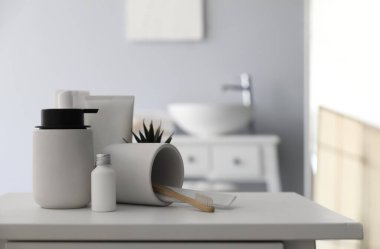 Diş fırçası ve banyo aksesuarlarıyla çevrilmiş bardaklar banyoda, yakın plan.