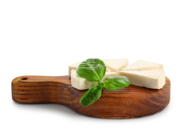 Beyaz arkaplanda lezzetli işlenmiş peynir ve fesleğen yaprakları olan tahta