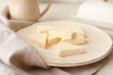 Açık arkaplanda lezzetli işlenmiş peynir üçgenleri olan tabak, yakın plan.