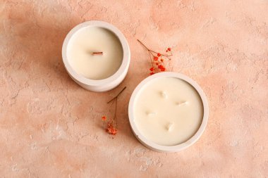 Elinde mumlar ve pembe arka planda çiçekler olan tutucular