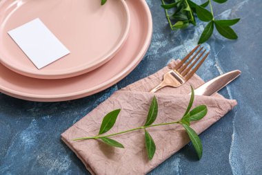 Boş davetiye kartı ve mavi masaya ağaç dalları ile güzel masa ayarları