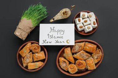 Yeni Yıl, Aladdin lambası, çimenler ve tatlılar koyu arkaplanda.